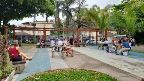 pessoas sentada curtindo área do parque. #paratodosverem