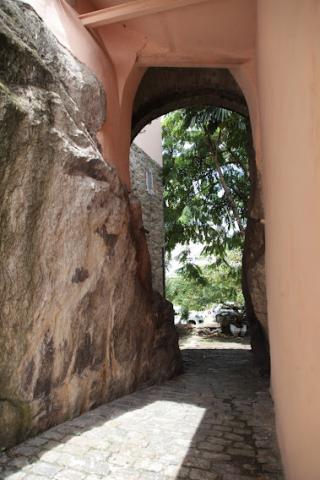 passagem ao lado da rocha com vegetação ao fundo. #paratodosverem