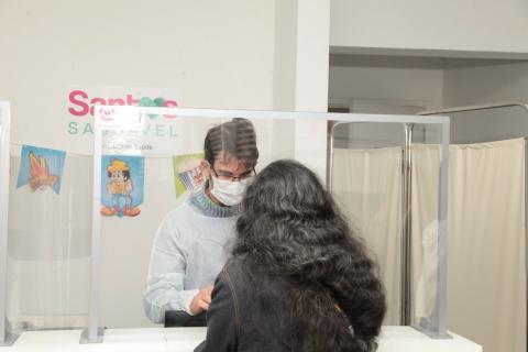 mulher é atendida em balcão diante de barreira de acrílico. #paratodosvere