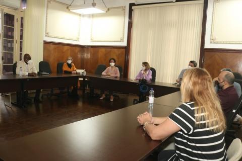 Gestores públicos sentados à mesa de reunião na sala de situação. #pracegover