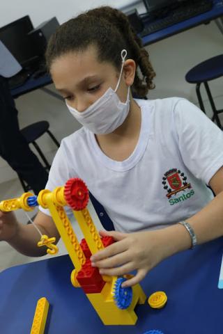 menina mexe em brinquedo de peças já montado. #paratodosverem