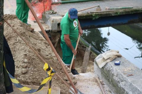 Homem trabalha na borda do canal. #paratodosverem