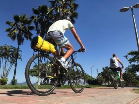 Dois ciclistas pedalando na ciclovia da praia #paratodosverem