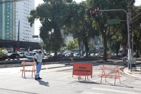 Agente orienta trânsito ao lado de placas de pista interditada. #paratodosverem