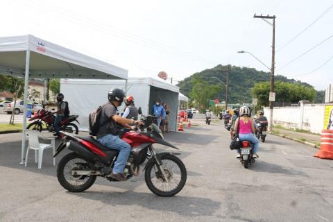 motociclistas sobre as motos na área da campanha. Há tendas armadas. #paratodosverem