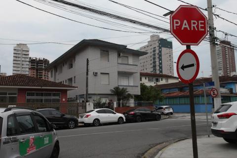 esquina de rua com placa de pare e outra indicando o sentido de direção. #paratodosverem
