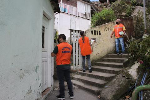 três tecnicos em frente a uma casa no morro #paratodosverem