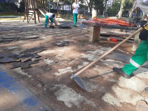 homens trabalhando em piso que está em obras. Com pás eles removem piso antigo. #paratodosverem