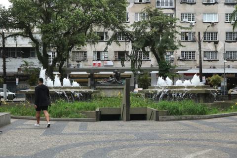 Banheiros da praça e fonte ao fundo  #paratodosverem