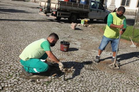 homens assentam mosaicos no piso. #paratodosverem