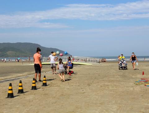 cobnes dispostos sobre a areia. Há pessoas em torno. #paratodosverem