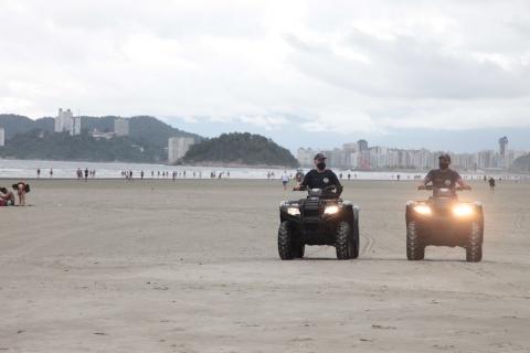 Guardas municipais conduzem quadriciclos na faixa de areia. #Paratodosverem