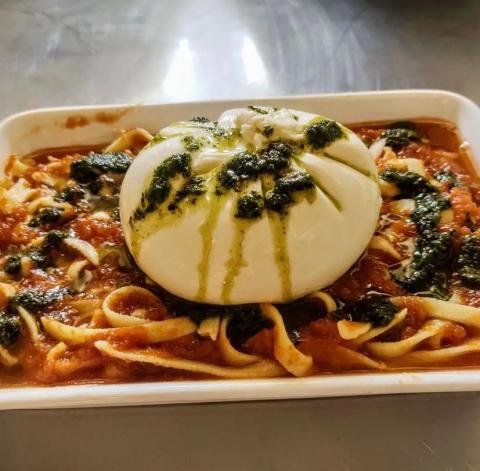 prato de macarrão coberto por burrata. #paratodosverem