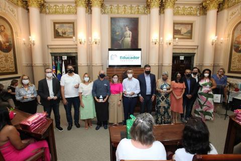 Várias pessoas homenageadas em pé durante a solenidade.#paratodosverem