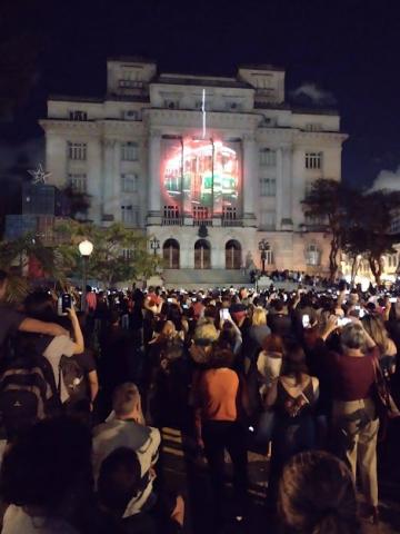 Praça mauá lotada de pessoas assistindo projeção na fachada da Prefeitura. #paratodosverem