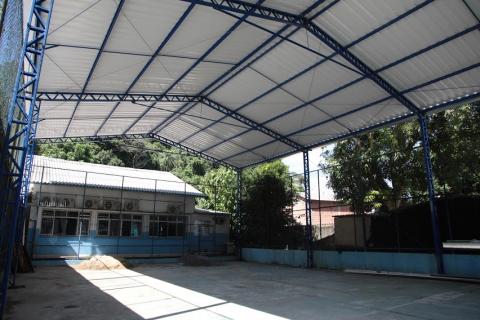 vista geral da quadra coberta com a escola ao fundo. #paratodosverem
