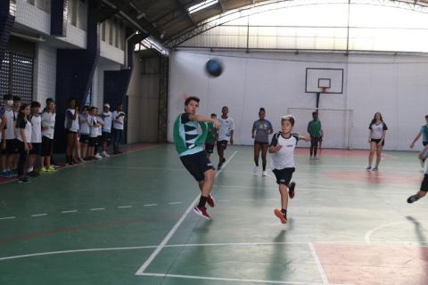 aluno arremessa bola em partida de handebol #paratodosverem