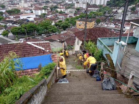 homens uniformizados trabalham junto a uma escadaria com trecho interditado. #paratodosverem 
