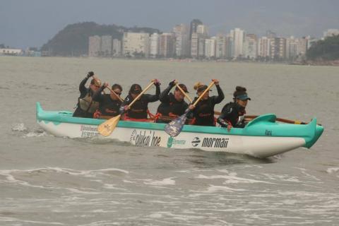 canoa é remada por mulheres. Dois remos aparecem fora da linha d'água. São seis mulheres dentro da embarcação. #paratodosverem