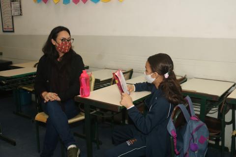 professora acompanha leitura de aluna. #paratodosverem