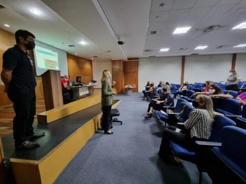 Pessoas acompanham palestra em auditório #paratodosverem