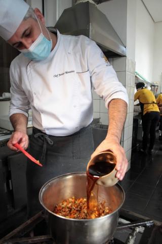 chefe despeja caldo escuro em panela. #paratodosverem