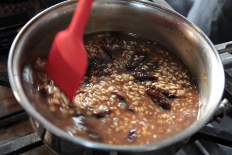 panela com arroz e caldo escuro. #paratodosverem