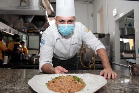 chefe segura o prato sobre uma bancada. #paratodosverem