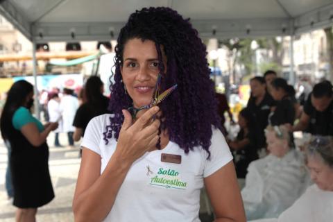 Jovem cabeleireira exibe tesoura na praça #paratodosverem