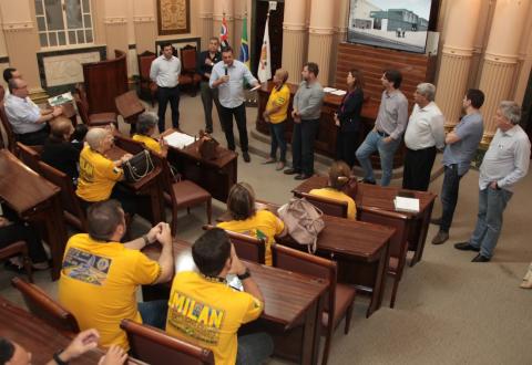 pessoas sentadas e autoridades em pé no auditório #paratodosverem