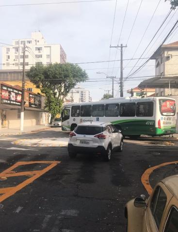 ônibus e carro atravessam a rotatória. #Paratodosverem