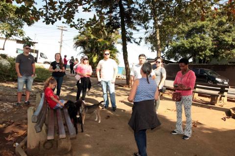 grupo de pessoas reunidas em praça de morro. Há vegetação em torno. #paratodosverem