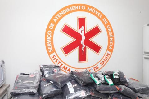 uniformes em mesa com parede atrás com simbolo do samu #paratodosverem