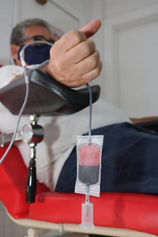 close de braço estendido em apoio com bolsa com sangue na parte de baixo.. #paratodosverem