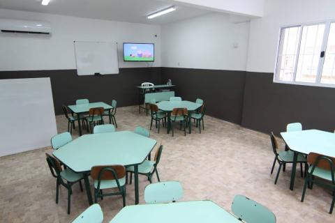 sala com mesas redondas e televisão #paratodosverem