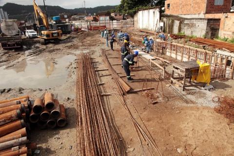 canteiro de obras em fase de fundação com vários homens trabalhando. #paratodosverem