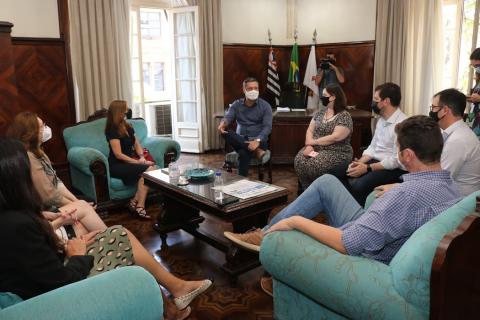 Pessoas conversando em sala na prefeitura #paratodosverem