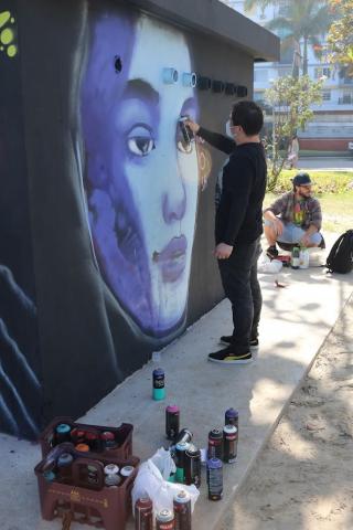 artista grafita rosto de sereie em face de muro. #paratodosverem