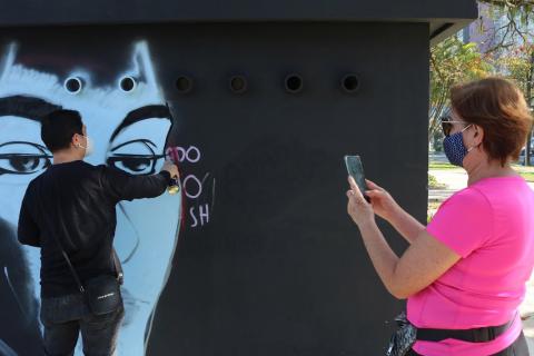 mulher fotografa artista fazendo o grafite. #paratodosverem