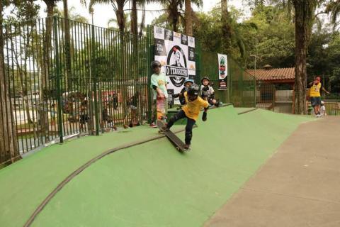 menino está com os dois pés sobre o skate, iniciando as manobras, ainda na beira da pista. #paratodosverem