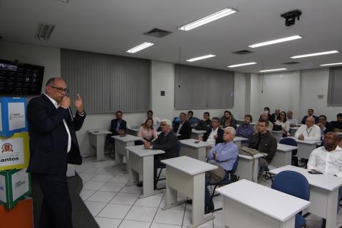 homem está falando ao público em uma sala. #paratodosverem