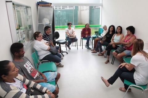 pessoas conversam sentadas em sala #paratodosverem