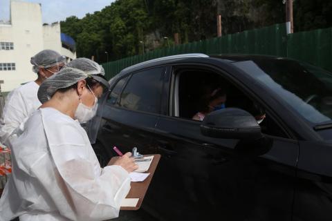 enfermeira anota em prancheta ao lado de carro #paratodosverem 