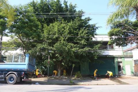 operários limpam porta do prédio #paratodosverem