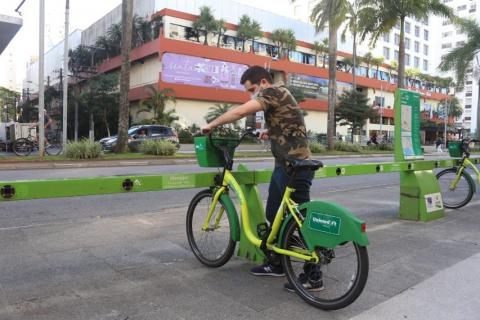 rapaz retira bicicleta de estação #paratodosverem