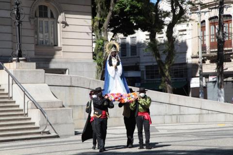 homens carregam imagem de santa #paratodosverem