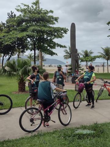 turistas param diante de monumento em homenagemao surfista no meio do jardim. #paratodosverem