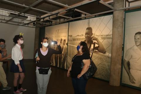 Mulheres tiram foto no Museu com fundo com foto do Pelé #paratodosverem
