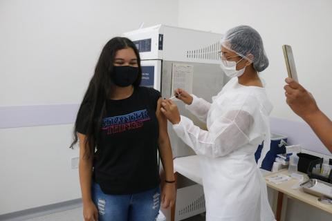 mulher aplica vacina em menina. #paratodosverem