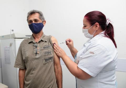 Idoso recebe aplicação de vacina no braço. #paratodosverem